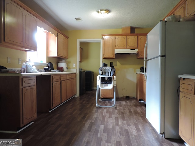 kitchen featuring a textured ceiling, white refrigerator, and dark hardwood / wood-style floors