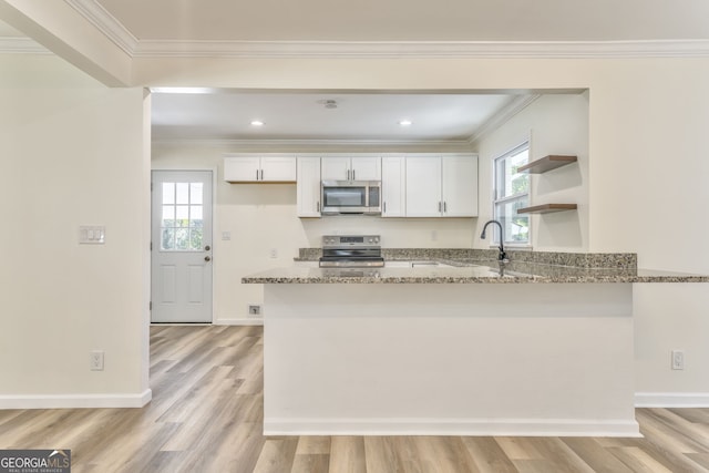 kitchen featuring appliances with stainless steel finishes, light hardwood / wood-style flooring, white cabinets, and light stone countertops