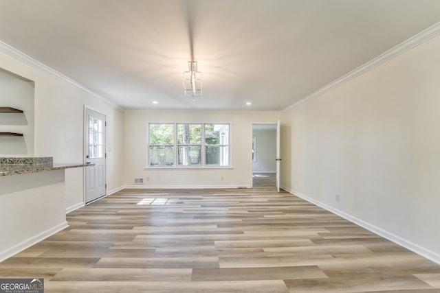 unfurnished dining area featuring ornamental molding and light wood-type flooring