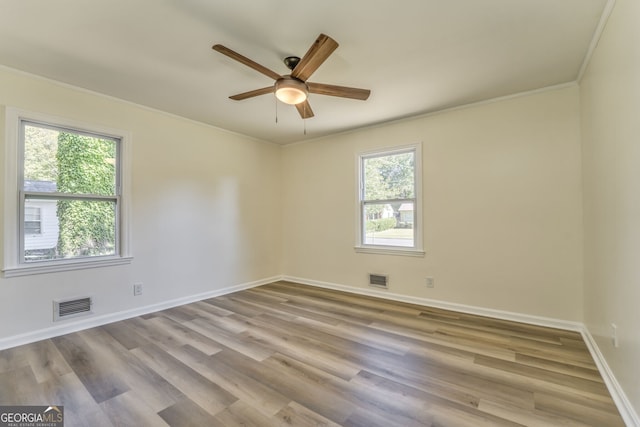 unfurnished room with crown molding, light hardwood / wood-style flooring, a healthy amount of sunlight, and ceiling fan