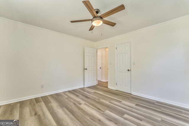 spare room featuring crown molding, light wood-type flooring, and ceiling fan