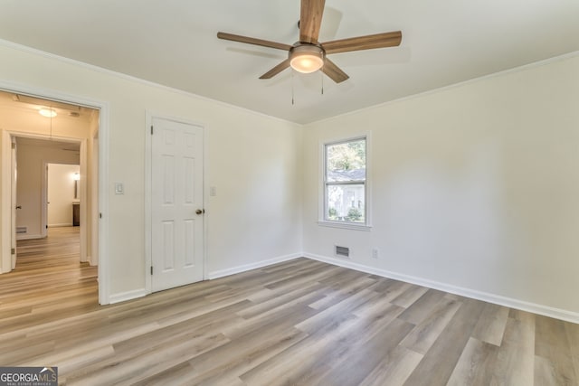 spare room with light hardwood / wood-style floors, crown molding, and ceiling fan