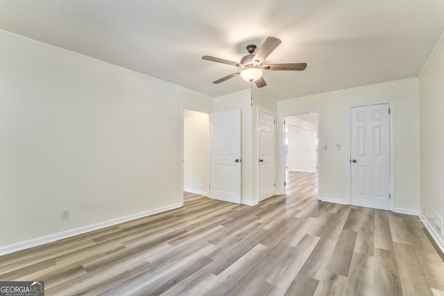 empty room with ceiling fan, ornamental molding, and light hardwood / wood-style flooring