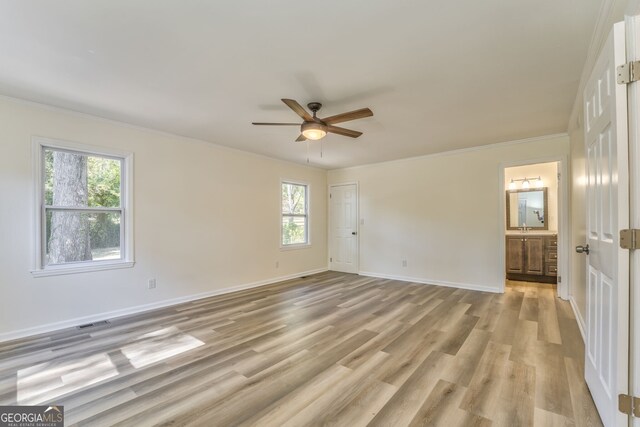 spare room featuring ceiling fan, crown molding, light hardwood / wood-style flooring, and plenty of natural light