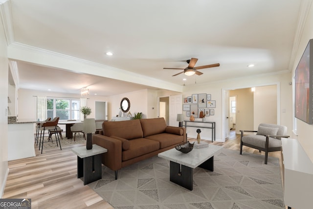 living room with ornamental molding, light hardwood / wood-style floors, and ceiling fan