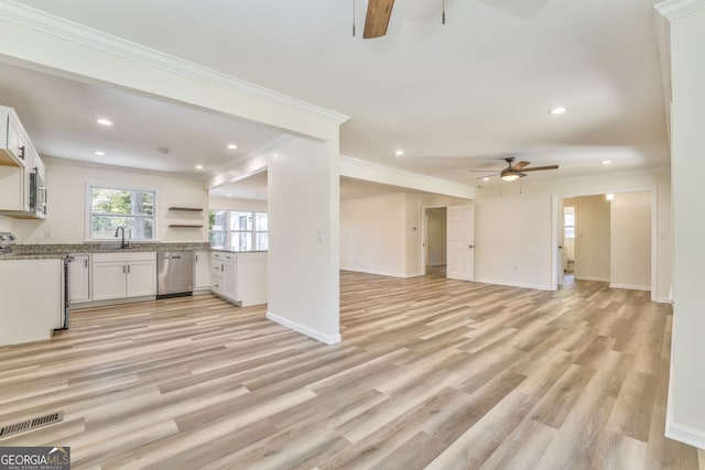 unfurnished living room featuring sink, crown molding, light wood-type flooring, and ceiling fan