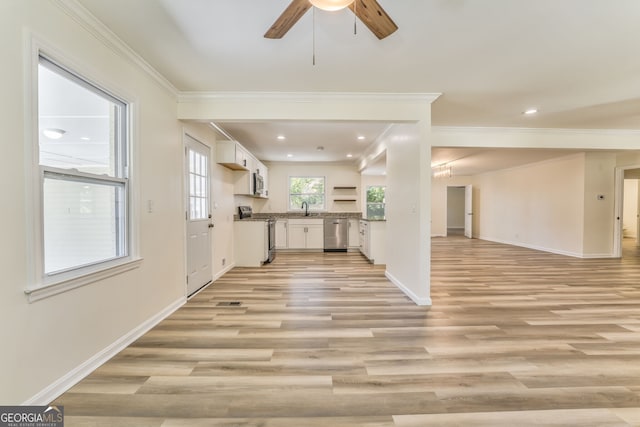 kitchen featuring white cabinets, appliances with stainless steel finishes, light wood-type flooring, crown molding, and sink