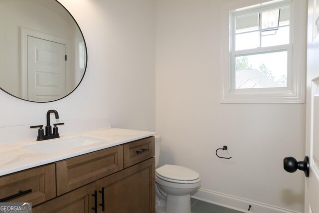 bathroom featuring tile patterned floors, vanity, and toilet