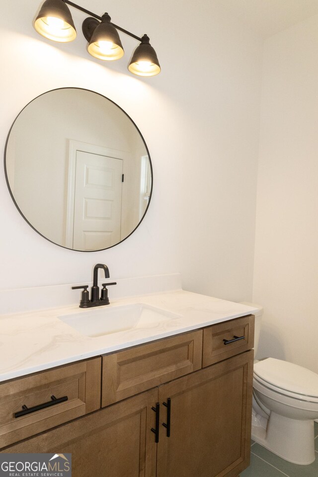 bathroom with tile patterned floors, vanity, and toilet