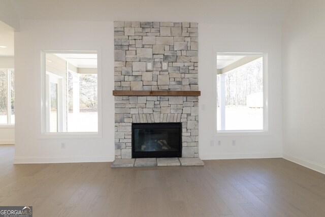 unfurnished living room featuring hardwood / wood-style floors, a fireplace, and a wealth of natural light