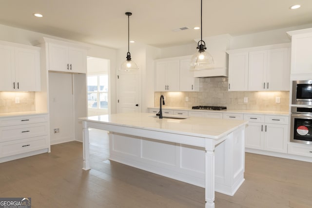 kitchen featuring sink, an island with sink, pendant lighting, and stainless steel gas cooktop