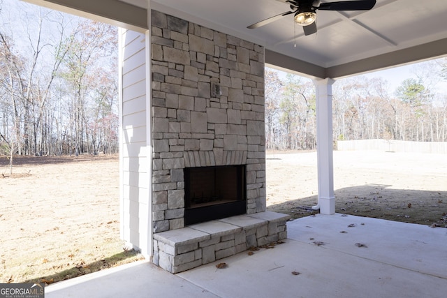 view of patio featuring an outdoor stone fireplace and ceiling fan