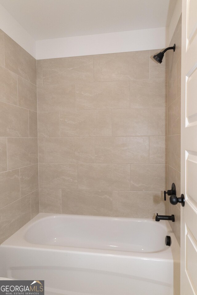 bathroom with tiled shower / bath combo