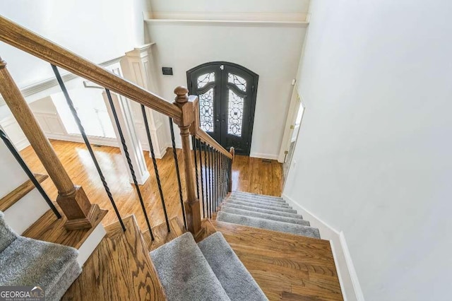 stairway featuring french doors and hardwood / wood-style flooring