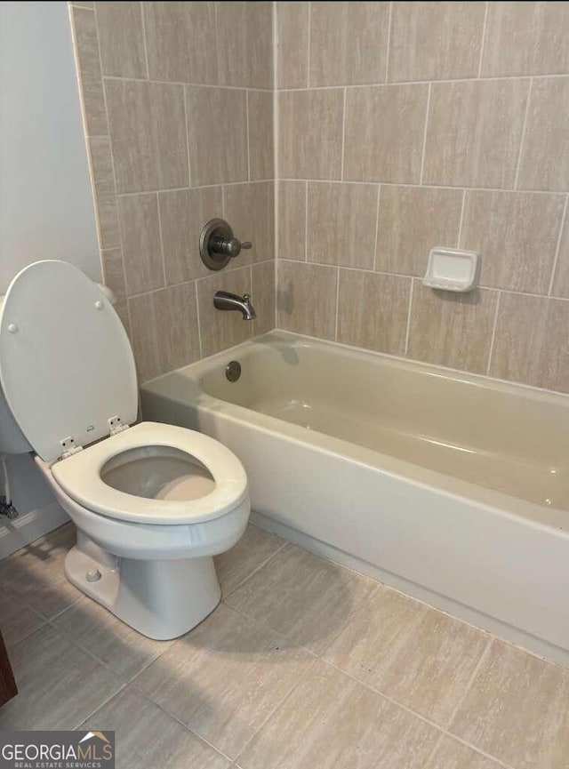 bathroom with toilet and tiled shower / bath