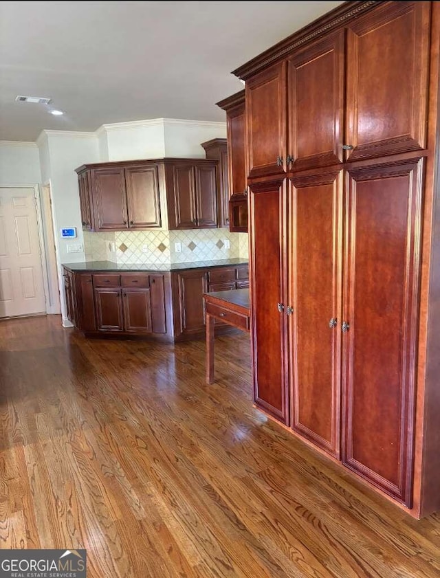 kitchen with crown molding, dark hardwood / wood-style floors, and tasteful backsplash