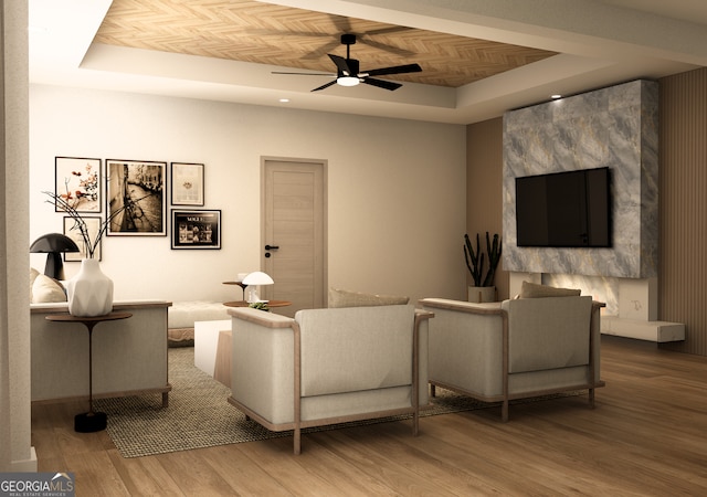 living room featuring hardwood / wood-style floors, a tray ceiling, and ceiling fan