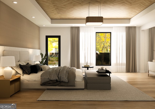 bedroom featuring light hardwood / wood-style floors and a tray ceiling