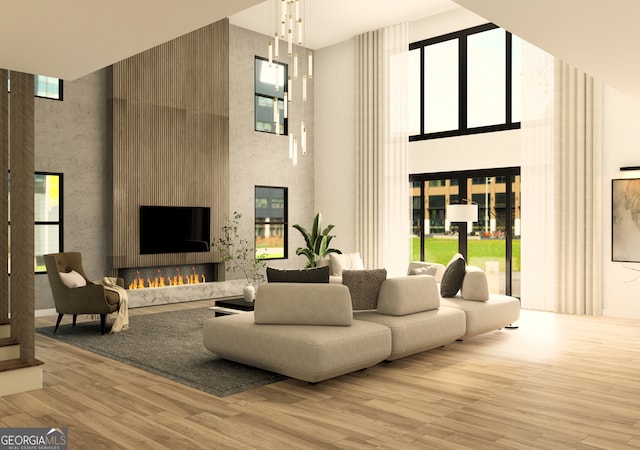 living room with a high ceiling, light wood-type flooring, and a fireplace