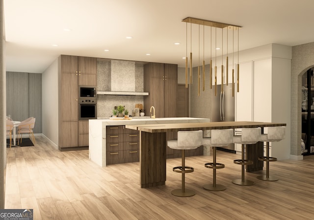 bar with tasteful backsplash, appliances with stainless steel finishes, light wood-type flooring, hanging light fixtures, and wall chimney exhaust hood