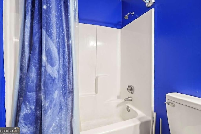 bathroom featuring shower / tub combo and toilet