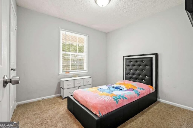 bedroom with a textured ceiling and light colored carpet