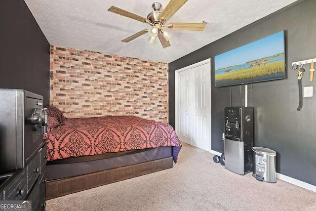 carpeted bedroom featuring a closet, ceiling fan, and a textured ceiling