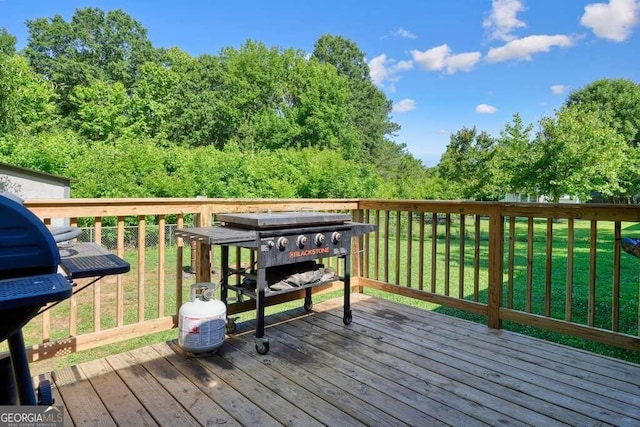 wooden terrace with a yard and a grill