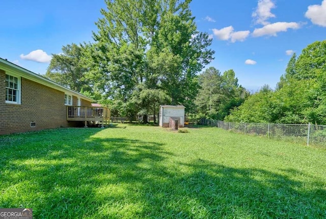 view of yard featuring a wooden deck and a shed