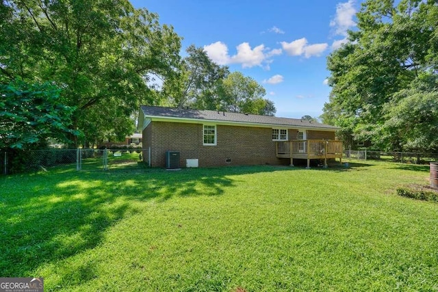 back of property featuring a deck and a lawn