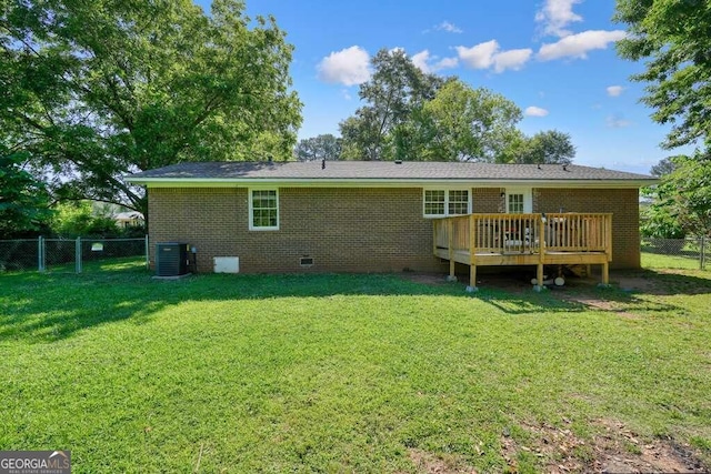 rear view of house with a wooden deck, a yard, and cooling unit