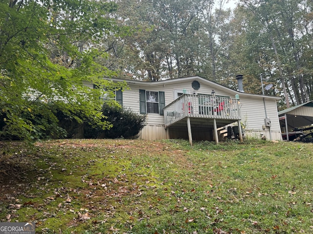 manufactured / mobile home with a wooden deck and a front yard