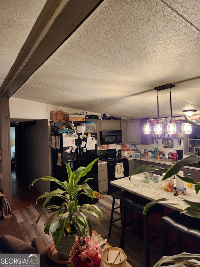 dining space with lofted ceiling, dark hardwood / wood-style floors, and a textured ceiling