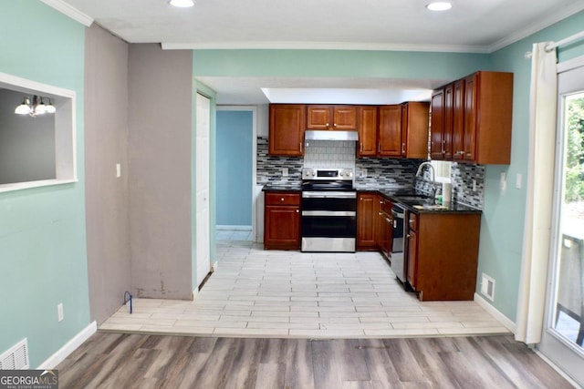 kitchen featuring appliances with stainless steel finishes, ornamental molding, sink, and light hardwood / wood-style floors