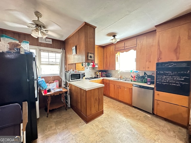 kitchen with tasteful backsplash, appliances with stainless steel finishes, sink, kitchen peninsula, and ceiling fan