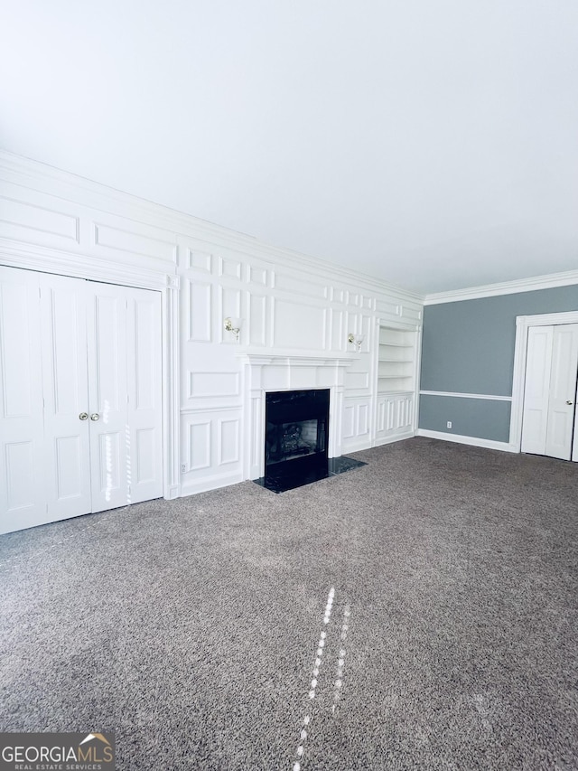 unfurnished living room with crown molding, carpet floors, and built in shelves