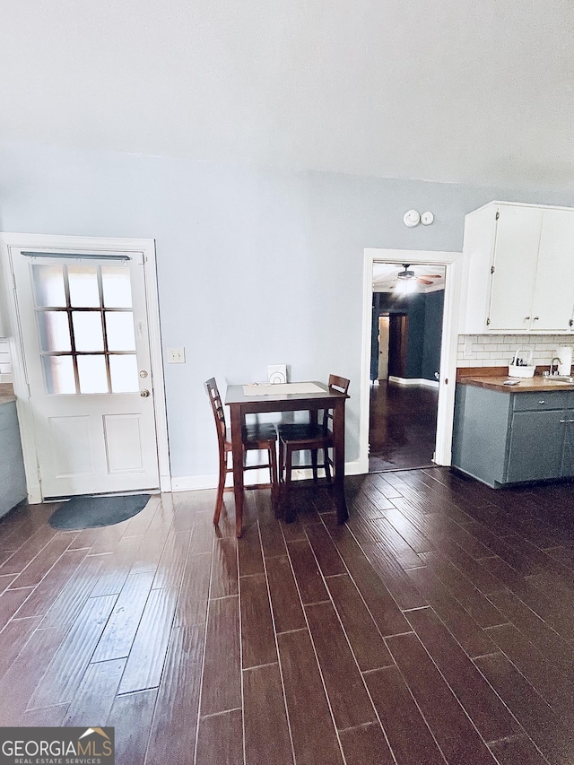 unfurnished dining area featuring dark hardwood / wood-style flooring, sink, and ceiling fan