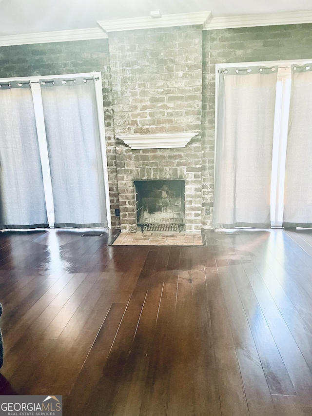 unfurnished living room with crown molding, dark wood-type flooring, and a fireplace