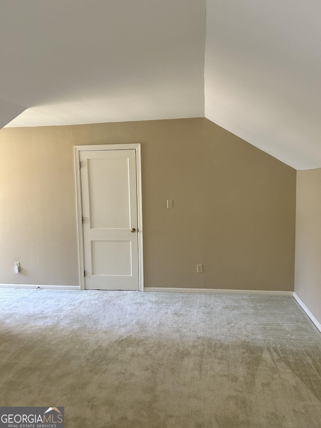 bonus room with lofted ceiling and carpet flooring