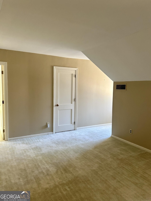 additional living space with lofted ceiling and light colored carpet