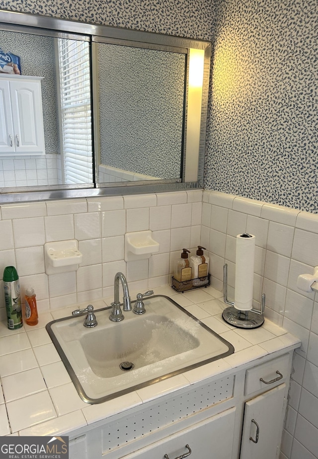 bathroom with vanity and tile walls