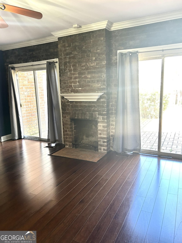 unfurnished living room with crown molding, dark hardwood / wood-style floors, and a healthy amount of sunlight