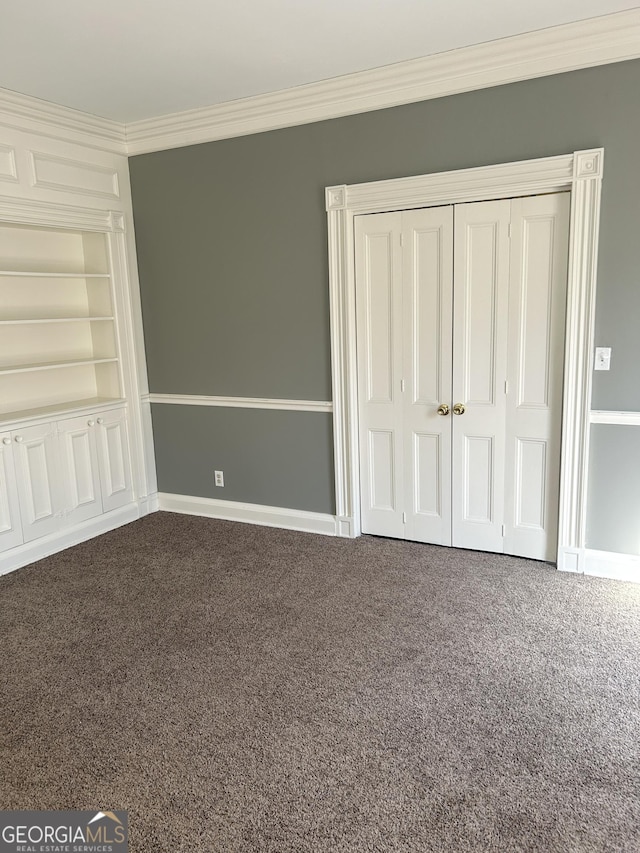 unfurnished bedroom featuring crown molding, a closet, and carpet