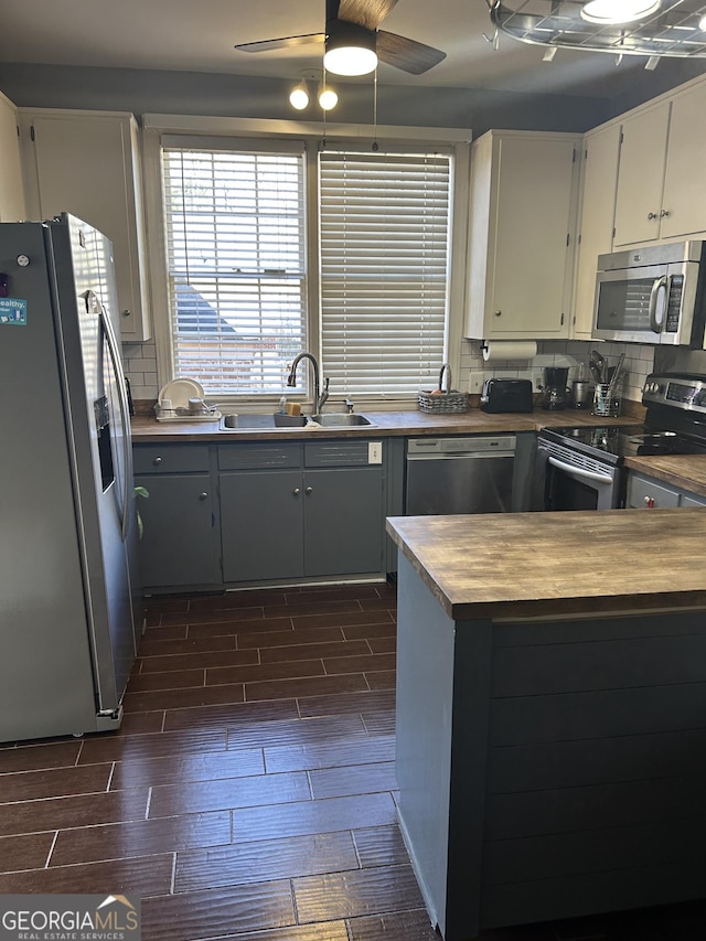 kitchen featuring gray cabinets, appliances with stainless steel finishes, tasteful backsplash, sink, and ceiling fan