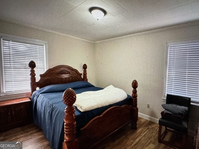 bedroom with ornamental molding and dark wood-type flooring