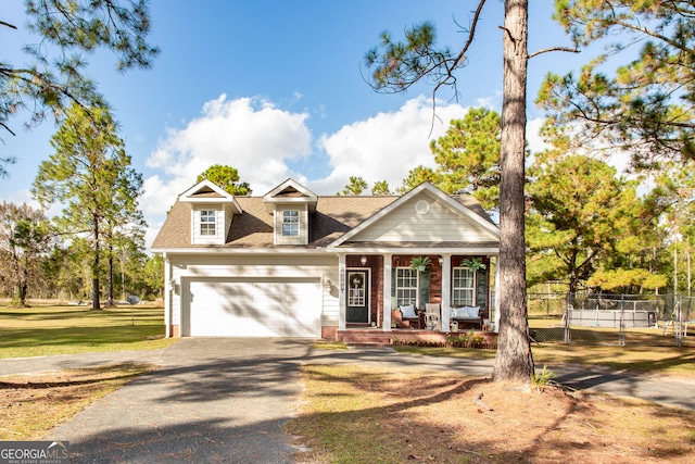 view of front of home with a porch, a front lawn, and a garage