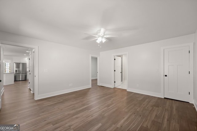 empty room with dark wood-type flooring and ceiling fan