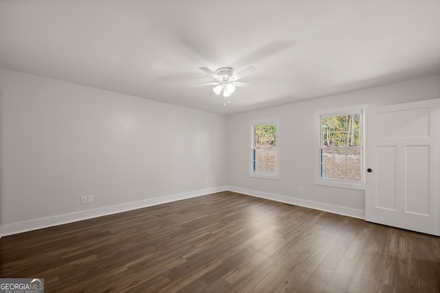 spare room featuring dark wood-type flooring and ceiling fan