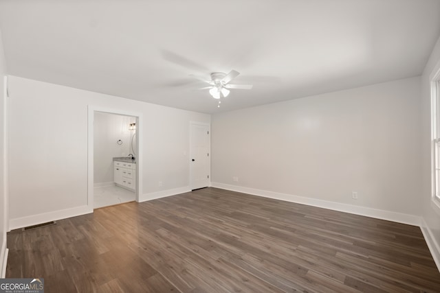 unfurnished bedroom featuring connected bathroom, ceiling fan, and dark hardwood / wood-style flooring