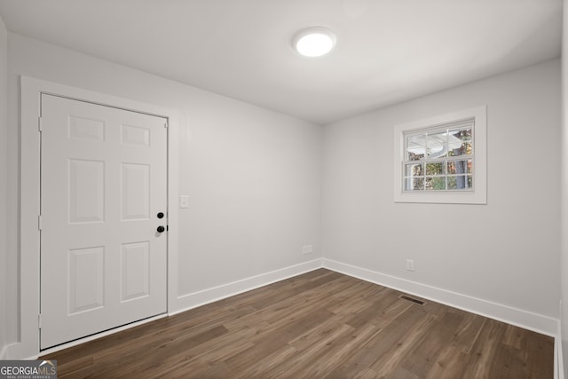 empty room with dark hardwood / wood-style flooring